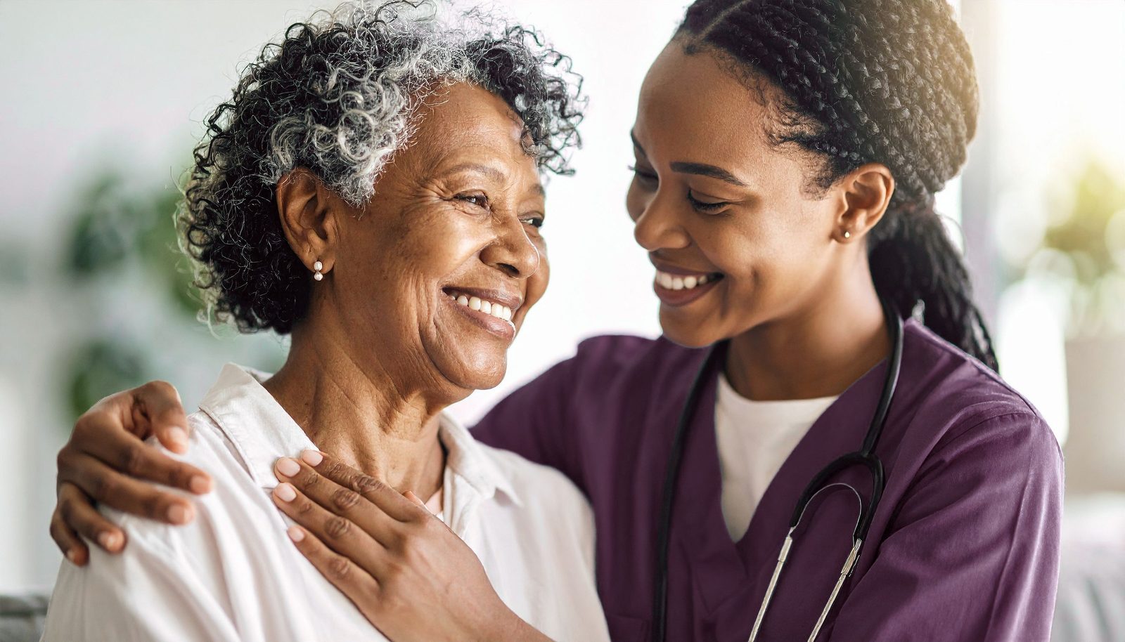 A carer sharing a warm moment with an older person at home